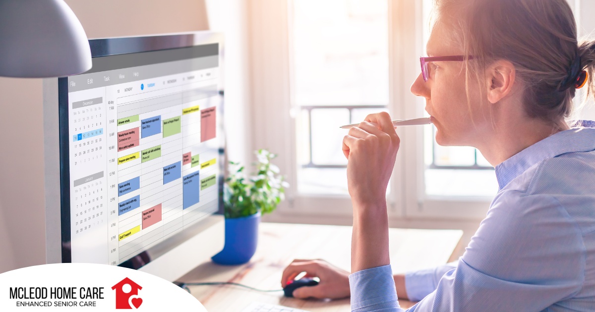 A woman looks at her calendar on her computer, showing an example of a time management tool that can help caregivers.